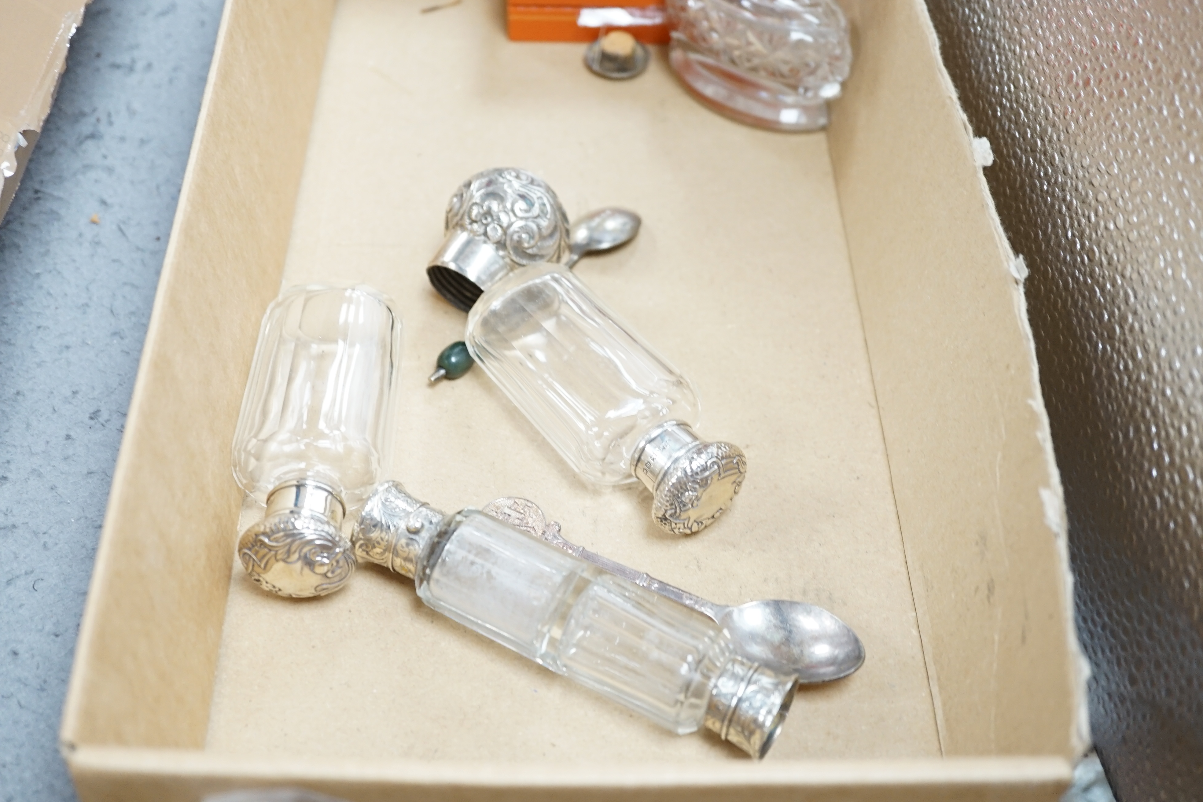 Seven assorted silver mounted glass scent bottles or toilet jars, and a repousse silver backed four piece dressing table set (a.f.) and other items including plated coffee spoons, place setting holders, etc.